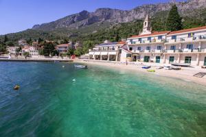 a body of water with a beach and a building at Apartments Damjan in Brist