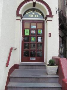a door to a hotel with a potted plant in front at Ashfields in Llandudno