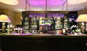 a bar in a restaurant with purple lighting at La Place Boutique Hotel in Antibes