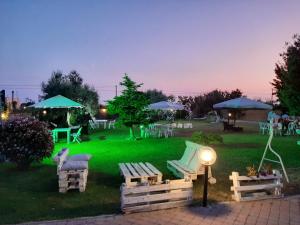 um parque com cadeiras, mesas e guarda-sóis à noite em Villa Elegance em Ladispoli