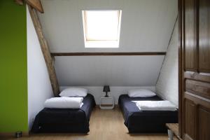 two twin beds in a room with a window at De Lucarne in Zottegem