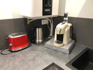 a kitchen counter with a coffee maker and a toaster at LE MUSCAT in Colmar