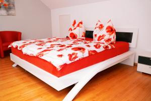 a bed with a red and white comforter and pillows at Panorama Traumblick in Bernkastel-Kues