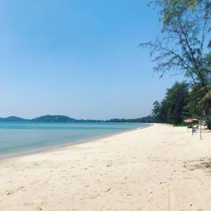 a sandy beach with trees and the ocean at Mae Phim, Rayong, Bali Residence Villa in Mae Pim