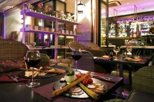 a restaurant with a table with wine glasses and food at La Place Boutique Hotel in Antibes