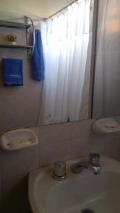 a bathroom with a sink and a mirror at Kume Ruca in Las Grutas