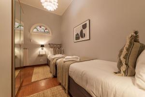 - une chambre avec 2 lits et un miroir dans l'établissement Lively Roma Trastevere renovated apartment - FromHometoRome, à Rome