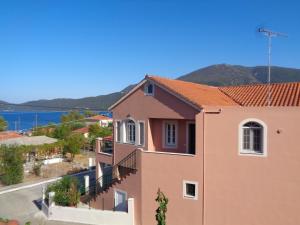 ein rosafarbenes Haus mit Meerblick in der Unterkunft Melissani House in Karavomylos