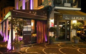 a store on the side of a street at night at La Place Boutique Hotel in Antibes