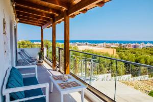 a balcony with a table and a view of the ocean at Villa Izabela in Hersonissos
