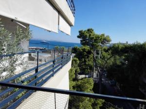 einen Balkon mit Blick auf eine Straße und das Meer in der Unterkunft Varkiza Apartment in Varkiza