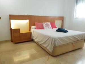 sypialnia z dużym łóżkiem z różowymi poduszkami w obiekcie Bel appartement au centre ville et de la plage w mieście Ceuta