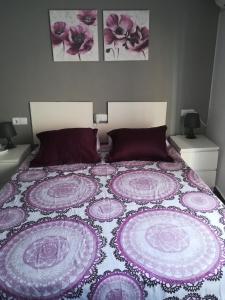 uma cama com um cobertor roxo e branco em Casa rural La Senyora em Veo