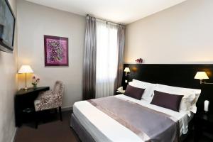a hotel room with a bed and a chair at La Place Boutique Hotel in Antibes