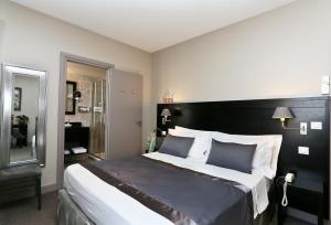 a bedroom with a large bed with a black headboard at La Place Boutique Hotel in Antibes