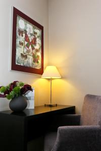 a living room with a table with a lamp and a couch at La Place Boutique Hotel in Antibes