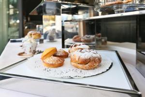 a display case with donuts on a plate on a counter at La Place Boutique Hotel in Antibes