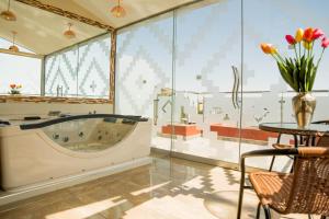 uma grande casa de banho com uma banheira, uma mesa e uma mesa; em Hotel Incamin Mirador em Arequipa mais 54 fotografias