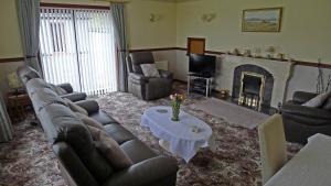 a living room with a couch and a fireplace at The Sheiling in Laide