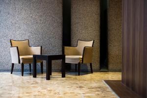 dwa krzesła i stół w pokoju w obiekcie Valie Hotel Hiroshima w mieście Hiroszima