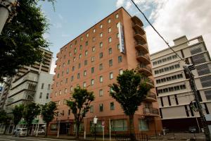 um edifício numa rua da cidade com edifícios em Sanco Inn Kuwana Ekimae em Kuwana