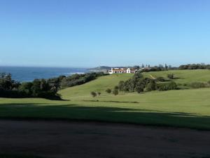 a view of a golf course with the ocean in the background at IRONWOOD LODGE in Pennington