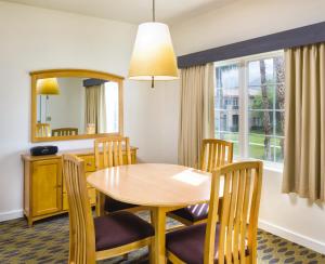 a dining room with a table and chairs and a mirror at WorldMark Cathedral City in Cathedral City