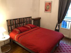 a bedroom with a bed with a red comforter at Le Sainte Marie in Compiègne