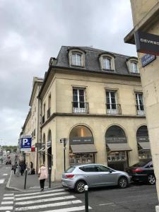 a building on a street with cars parked in front of it at Le Sainte Marie in Compiègne