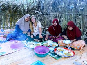 龙目岛库塔Perwita Homestay的一群坐在地上吃着食物的妇女 更多37张照片