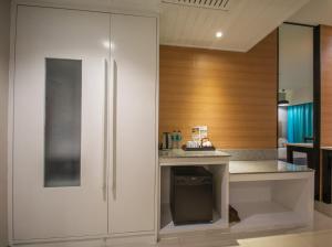 a kitchen with white cabinets and a counter at Peach Hill Resort - SHA Extra Plus in Kata Beach
