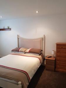 a bedroom with a bed and a wooden dresser and a bed sidx sidx sidx at 3 Laurel Court in Ulverston