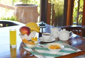a table with a breakfast of fruit and a cup of coffee at IRONWOOD LODGE in Pennington