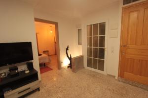Sala de estar con TV y puerta a un dormitorio en Can Clos Bonet carrer Colon, en Amposta