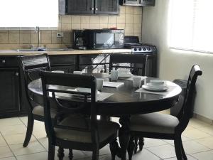 una cucina con tavolo e sedie e una cucina con forno a microonde di Apartamento Siesta Del Sol II a Puerto Peñasco