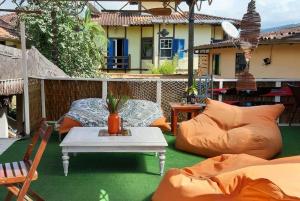 patio al aire libre con almohadas, mesa y sofá en Hostel Sereia do Mar, en Paraty