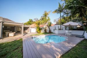 a backyard with a swimming pool and a wooden deck at 182 Old Transkei Road in East London
