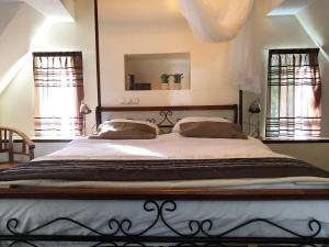 a bedroom with a large bed with two windows at The Pelgrim House in Sint Jacobiparochie