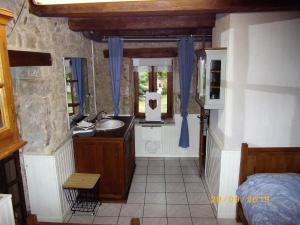 a bathroom with a sink and a mirror and a bed at Maison du Moulin Galuzot in Saint-Vallier