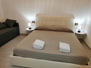 un grande letto in una camera con divano di Casa di Chia Buggerru a Buggerru