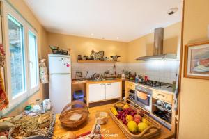 a kitchen with a table with fruit on it at Le Petit Paradis in Prémian