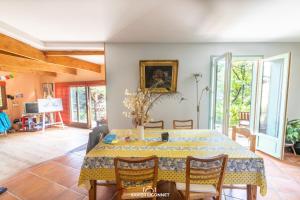 a dining room with a table and chairs at Le Petit Paradis in Prémian