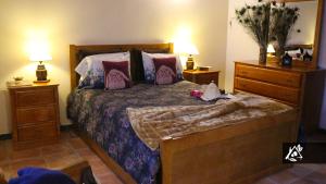 a bedroom with a bed with two dressers and two lamps at Quinta do Paraíso in Porto Martins +44 photos