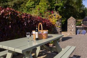 a picnic table with two bottles and glasses of wine at Millbrae Lodges in Belfast