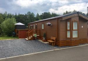 a small wooden cabin with a bench and a porch at Logi-Bear Lodge with Hot Tub in Felton