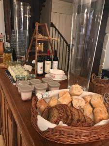 un tavolo con un cesto di pane e bottiglie di vino di Logis Hôtel DOMAINE du MOULIN a Saint-Avold