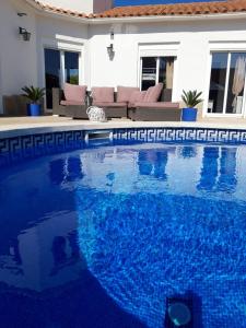 Villa voor 8 personen met zwembad في كالافات: مسبح ازرق كبير امام المنزل