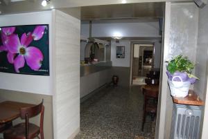 corridoio con tavolo e dipinto di fiori su un muro di Albergo della Posta a Trivero