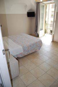 a small bedroom with a bed and a tiled floor at Albergo della Posta in Trivero