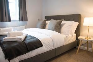 a bedroom with a large bed with white and gray pillows at Appleby Darlington in Darlington